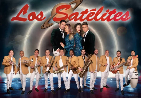 Fotografía oficial de la Orquesta Los Satélites con todos sus integrantes para la gira 2025. Los cantantes en el centro, vestidos de gala, y los músicos con trajes en tonos dorados y blancos, posando con sus instrumentos frente a un fondo temático espacial.